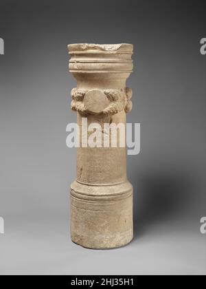 Cippus calcaire d'Olympianos début 3rd siècle A.D. les monuments funéraires romains et chypriotes de ce type étaient communs à Chypre de la fin hellénistique à la période romaine.Chacun a été gravé avec une formule standard d'adieu s'adressant directement au défunt dans le chant.Parfois un commentaire est ajouté, comme "personne n'est immortel".Ici, l'inscription en grec se lit simplement comme suit: 'Good Olympianos, adieu.'Ci-dessus est une couronne décorée de cônes de pin et de fruits qui borde un disque circulaire simple sur lequel un portrait du défunt peut avoir été peint.Cippus calcaire d'Olympianos 241821 Banque D'Images