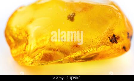 Photographie macro à veined ambre.Massage du visage et du corps avec pierres semi-précieuses et concept de minéraux.Grande pierre orange transparente sur fond blanc Banque D'Images