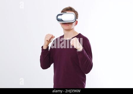 Jeune et portant des lunettes de réalité virtuelle isolées sur fond blanc.Casque à technologie lunettes VR et jeu de boxe.Copier l'espace et la maquette Banque D'Images