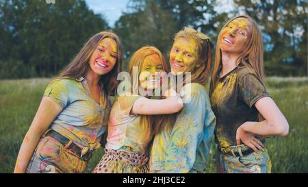 Filles gaies posant étalées dans de la poudre multicolore. Banque D'Images