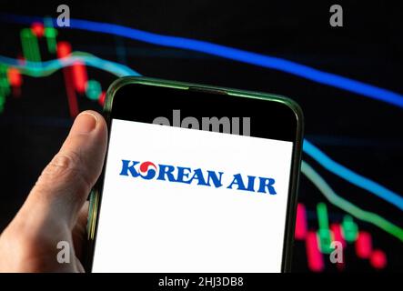 Dans cette illustration photo, le logo de la compagnie aérienne et du porte-drapeau de Corée du Sud, Korean Air, est affiché sur un smartphone avec un graphique d'indice boursier économique en arrière-plan. Banque D'Images