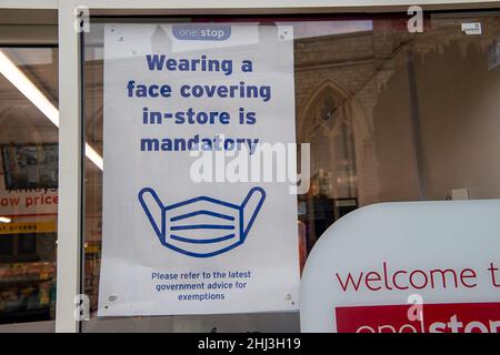 Chertsey, Surrey, Royaume-Uni.26th janvier 2022.Un signe de masque facial dans une fenêtre de magasin.Les mesures Covid-19 sont levées en Angleterre à partir de demain 27th janvier 2022, bien que certains magasins prévoient toujours de demander aux gens de porter des masques pour aider à arrêter la propagation de la variante Covid-19 Omicron.Crédit : Maureen McLean/Alay Banque D'Images