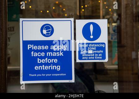 Chertsey, Surrey, Royaume-Uni.26th janvier 2022.Un signe de masque facial dans une fenêtre de magasin.Les mesures Covid-19 sont levées en Angleterre à partir de demain 27th janvier 2022, bien que certains magasins prévoient toujours de demander aux gens de porter des masques pour aider à arrêter la propagation de la variante Covid-19 Omicron.Crédit : Maureen McLean/Alay Banque D'Images