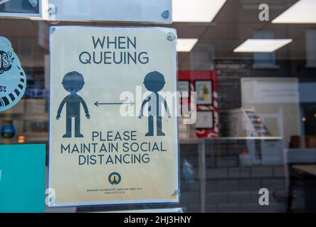 Chertsey, Surrey, Royaume-Uni.26th janvier 2022.Un signe de distance sociale dans une fenêtre de magasin.Les mesures Covid-19 sont levées en Angleterre à partir de demain 27th janvier 2022, bien que certains magasins prévoient toujours de demander aux gens de porter des masques pour aider à arrêter la propagation de la variante Covid-19 Omicron.Crédit : Maureen McLean/Alay Banque D'Images