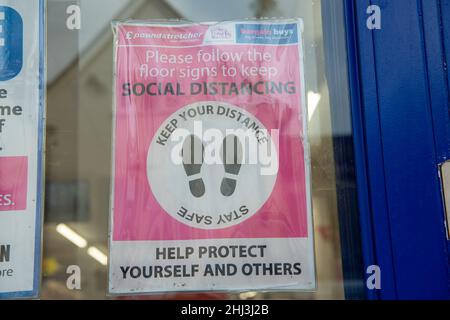 Chertsey, Surrey, Royaume-Uni.26th janvier 2022.Un signe social de distanciation dans la fenêtre de Poundbrancher.Les mesures Covid-19 sont levées en Angleterre à partir de demain 27th janvier 2022, bien que certains magasins prévoient toujours de demander aux gens de porter des masques pour aider à arrêter la propagation de la variante Covid-19 Omicron.Crédit : Maureen McLean/Alay Banque D'Images