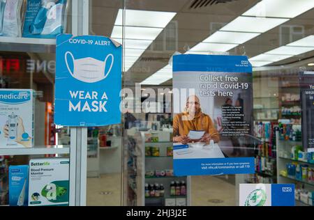 Chertsey, Surrey, Royaume-Uni.26th janvier 2022.Un signe de masque facial dans la fenêtre d'une pharmacie.Les mesures Covid-19 sont levées en Angleterre à partir de demain 27th janvier 2022, bien que certains magasins prévoient toujours de demander aux gens de porter des masques pour aider à arrêter la propagation de la variante Covid-19 Omicron.Crédit : Maureen McLean/Alay Banque D'Images