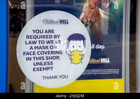 Chertsey, Surrey, Royaume-Uni.26th janvier 2022.Un masque de visage dans la fenêtre de William Hill Paris shop.Les mesures Covid-19 sont levées en Angleterre à partir de demain 27th janvier 2022, bien que certains magasins prévoient toujours de demander aux gens de porter des masques pour aider à arrêter la propagation de la variante Covid-19 Omicron.Crédit : Maureen McLean/Alay Banque D'Images