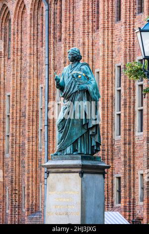 Torun, Pologne - 11 août 2021.Monument de Nicolaus Copernicus inscrit Thorunensis.La vieille mairie en arrière-plan. Banque D'Images