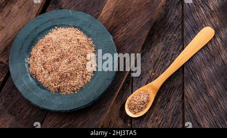 Graines de lin écrasées dans le bol en bois - Linum usitatissimum Banque D'Images