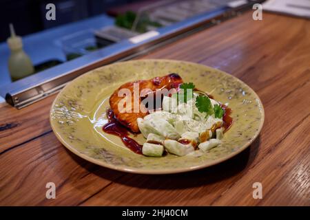 Filet de saumon japonais au design minimaliste avec légumes et norii émaillés de sauce teriyaki sur une assiette au design moderne Banque D'Images