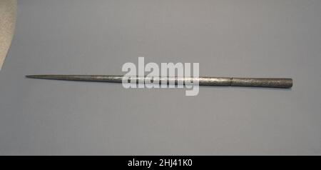 Arbre ou mandrin pour la découpe de jade Chine du 20th siècle ces forets en acier avec des pointes émoussées (zhuangding ou dingzi en chinois), des têtes plates (tuozi), ou des têtes de découpe (wazi) sont utilisés pour la découpe de relief élevé, la sous-coupe, et la mise en forme fine de petits travaux de jade.L'artisan tient le jade d'une main contre le foret, qui est monté sur un arbre rotatif.Il ou elle fait tourner l'arbre à l'aide de la pédale, tout en appliquant continuellement des abrasifs, habituellement le sable mélangé à l'eau, à la pointe de la foreuse, qui coupe le jade.Arbre ou mandrin pour sculpture en jade.Chine.20th siècle.Acier.Pierre dure Banque D'Images