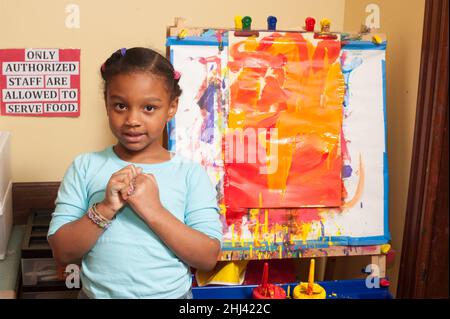 Éducation préscolaire 4-5 ans portrait de fille debout près de chevalet Banque D'Images