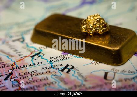 Gros plan d'une barre d'or et d'un nugget d'or en haut d'une carte du Pérou Banque D'Images