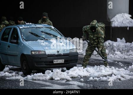 Athènes.26th janvier 2022.Les forces armées travaillent pour enlever un véhicule coincé à Athènes, en Grèce, le 26 janvier 2022, deux jours après la chute de neige importante a frappé la ville.Credit: Lefteris Partsalis/Xinhua/Alamy Live News Banque D'Images
