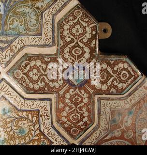 Carreaux en forme de croix 13th siècle ce carrelage en forme de croix avec un motif de feuilles symétrique faisait autrefois partie d'un panneau de carreaux en forme d'étoile et de croix ornant les murs d'un bâtiment Ilkhanid.Probablement produit dans le centre de céramique de Kashan en Iran central, il affiche de nombreuses caractéristiques typiques de ce site, y compris l'utilisation de lustre opulent glaçure, une composition équilibrée, et les spirales et les points qui remplissent l'arrière-plan.Carreaux en forme de croix 450455 Banque D'Images