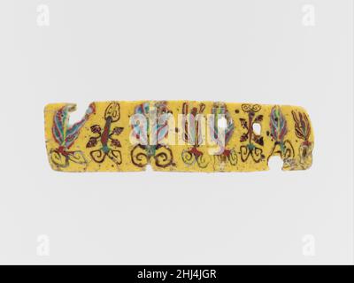 Incrustation en mosaïque de verre 1st siècle C.-B.–1st siècle A.D. Egyptien, romain Opaque jaune;Décoration en blanc opaque, rouge et vert grisâtre, et violet foncé translucide apparaissant en noir.bande horizontale étroite, légèrement effilée vers la droite et arrondie bord droit.motif floral répétitif asymétrique avec des palmettes, des boutons de lotus et des tiges flanquées de quatre feuilles de lierre.brisée et réparée avec quelques fissures et des pertes;Dessus, dessous et bords rodés et polis; piqûres profondes de certaines bulles de surface. Cette pièce est coupée de la même barre de verre en mosaïque que 17.194.377, mais la décoration apparaît en mi Banque D'Images
