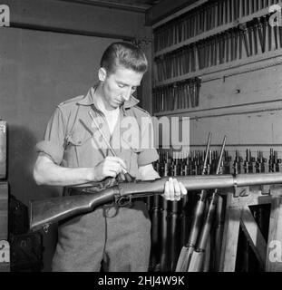 Le footballeur international de Swansea Town et Wales Cliff Jones au service de son service national au sein du régiment d'artillerie royale de la troupe des rois de l'armée britannique. Ici, il nettoie son fusil pour inspection à la caserne de St John's Wood.14th octobre 1957. Banque D'Images