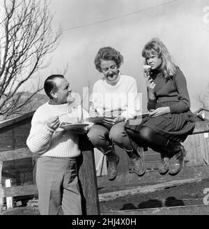 L'acteur John Mills, l'épouse Mary Hayley Bell et leur fille Hayley Mills photographiés au soleil à Downham, dans le Lancashire, étudiant le scénario du film « sifflet Down the Wind ».Le film est tourné dans une ferme et Hayley y est.Le script a été adapté d'un roman écrit par Mary Hayley Bell.21st février 1961. Banque D'Images