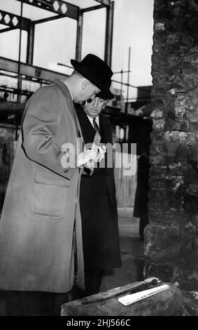 Dans la nuit du 26th février 1959, Mme Amy Browell, une shopkeeper de 71 ans, a été assassinée, ses locaux ont également été mis à sac et la caisse vidée.L'inspecteur détective J Angus (à gauche) de Newcastle CID et le surintendant détective J Kennedy de la cour d'Écosse examinent des indices près de la scène du meurtre.À leurs pieds se trouve une barre de fer, considérée comme une arme de meurtre possible.27th février 1959. Banque D'Images