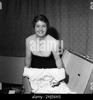 Anne Reid, actrice de 21 ans, chez elle à Kensington, a fait ses bagages avant de partir pour l'aéroport de Londres.Elle va à Beyrouth avec la Compagnie shakespearienne Regents Park pour deux semaines.La Société présentera Hamlet et la douzième nuit.20th août 1956. Banque D'Images