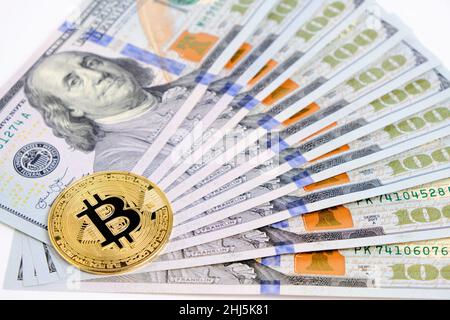 Ensemble déplié de billets de cent dollars et une pièce de monnaie en bitcoin Banque D'Images