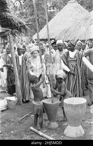 La reine Elizabeth observe deux enfants meuler du maïs lors d'une visite à Hangha, dans la province orientale de la Sierra Leone, le 1st décembre 1961 Banque D'Images