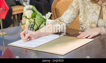 le portrait fragmentaire de la femme qui signe l'engagement de mariage coloré Banque D'Images