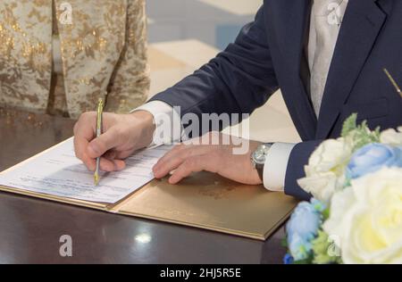 le portrait fragmentaire de l'homme qui signe l'engagement de mariage coloré Banque D'Images