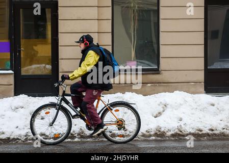 RIGA, LETTONIE.2nd février 2021.Un homme roule à vélo sur une route glissante. Banque D'Images