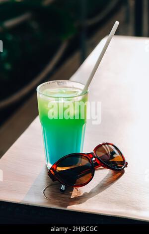 Boire un cocktail en vacances à côté de la piscine. Smoothie détox aux fruits de couleur. Vacances d'été. Banque D'Images