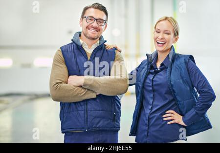 Nous faisons de cet entrepôt une marque.Portrait de deux directeurs d'étage travaillant dans un grand entrepôt. Banque D'Images