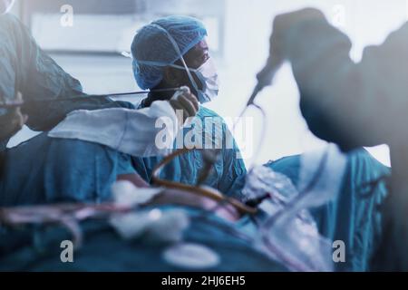 La référence en matière d'excellence chirurgicale.Photo d'une équipe dédiée de jeunes chirurgiens effectuant une chirurgie sur un patient dans une salle d'opération. Banque D'Images