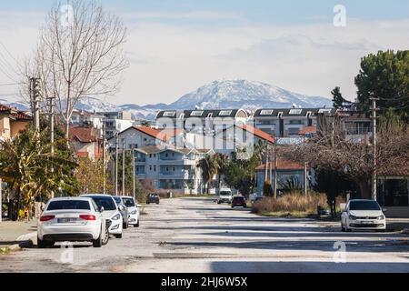 Side, Turquie -20 janvier 2022: Rue de la ville avec différentes maisons basses, parking de voitures et montagne sur fond Banque D'Images