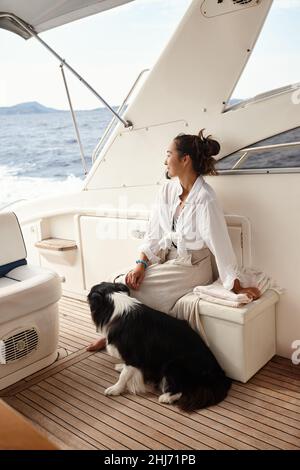 Femme avec chien sur yacht blanc dans la mer Banque D'Images
