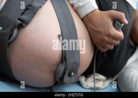 Gros plan femme enceinte sur la table de l'hôpital pendant la cardiotographie de contrôle médical.Consulter un médecin gynécologue à la clinique pour un consultant en grossesse Banque D'Images
