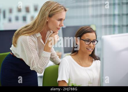 Il n'y a pas de questions stupides.Prise de vue de deux belles collègues féminins dans un dilemme sur un travail sur un ordinateur dans un bureau. Banque D'Images