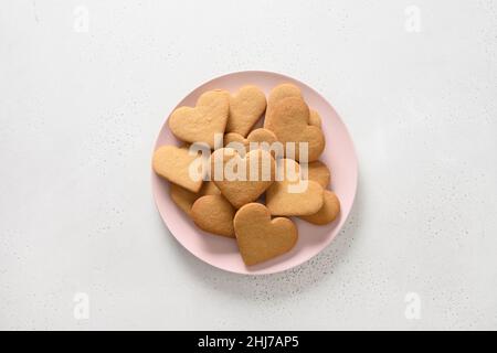 Biscuits en forme de coeur de la Saint-Valentin sur plaque rose isolée sur fond blanc.Vue de dessus. Banque D'Images
