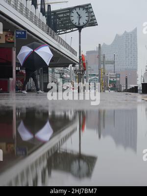 Hambourg, Allemagne.27th janvier 2022.Un homme avec un parapluie marche sous la pluie à travers les étapes de l'atterrissage dans le port de Hambourg.Credit: Marcus Brandt/dpa/Alay Live News Banque D'Images