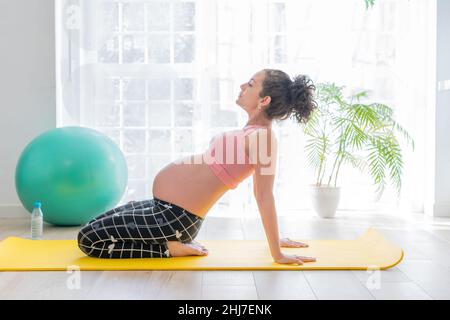 jeune femme enceinte sur un tapis de fitness faisant des exercices de relaxation, de méditation et de yoga. concept de soins de santé de grossesse Banque D'Images
