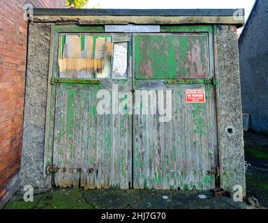 Garages délabrés avec portes en bois vert et peinture écaillée Banque D'Images