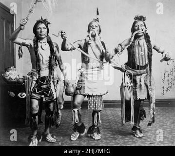 Trois hommes amérindiens, en vêtements traditionnels, se sont posés comme s'ils avaient fait une danse de serpent. Gerhard Sisters, photographe. c 1905. Banque D'Images