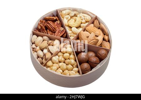 boîte cadeau ronde en bois avec cellules triangulaires et mélange de différents types de noix pour une alimentation saine des végétariens isolés sur blanc, personne. Banque D'Images