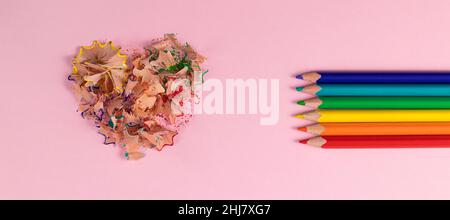 Banderole avec crayons de couleur aiguisés et copeaux de crayon en forme de cœur.Crayons Rainbow ou LGBT.Décoration pour la Saint-Valentin.Vue de dessus Banque D'Images