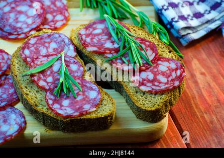 sandwichs à la saucisse sur un panneau en bois et épices en gros plan Banque D'Images