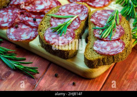 sandwichs à la saucisse sur un panneau en bois et épices en gros plan Banque D'Images