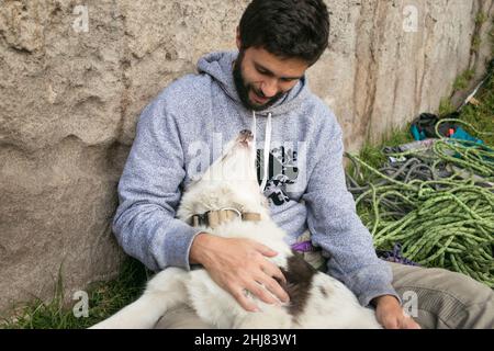 L'homme hispanique et la frontière marron collie s'aiment l'un l'autre en plein air Banque D'Images