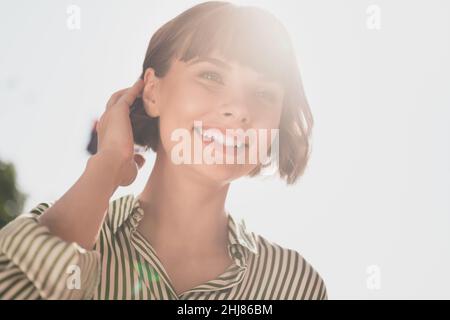 Photo de charmante belle belle dame brillant blanc sourire toucher bob coupe de cheveux porter chemise rayée ville urbaine à l'extérieur Banque D'Images