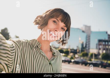 Photo portrait femelle étudiant dans des vêtements décontractés souriant marchant dans la rue de la ville voyageant sur les vacances parlant selfie Banque D'Images