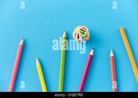 crayons de coloriage et bandes en caoutchouc sur fond bleu Banque D'Images