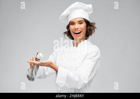 chef féminin avec désinfectant pour les mains ou savon liquide Banque D'Images